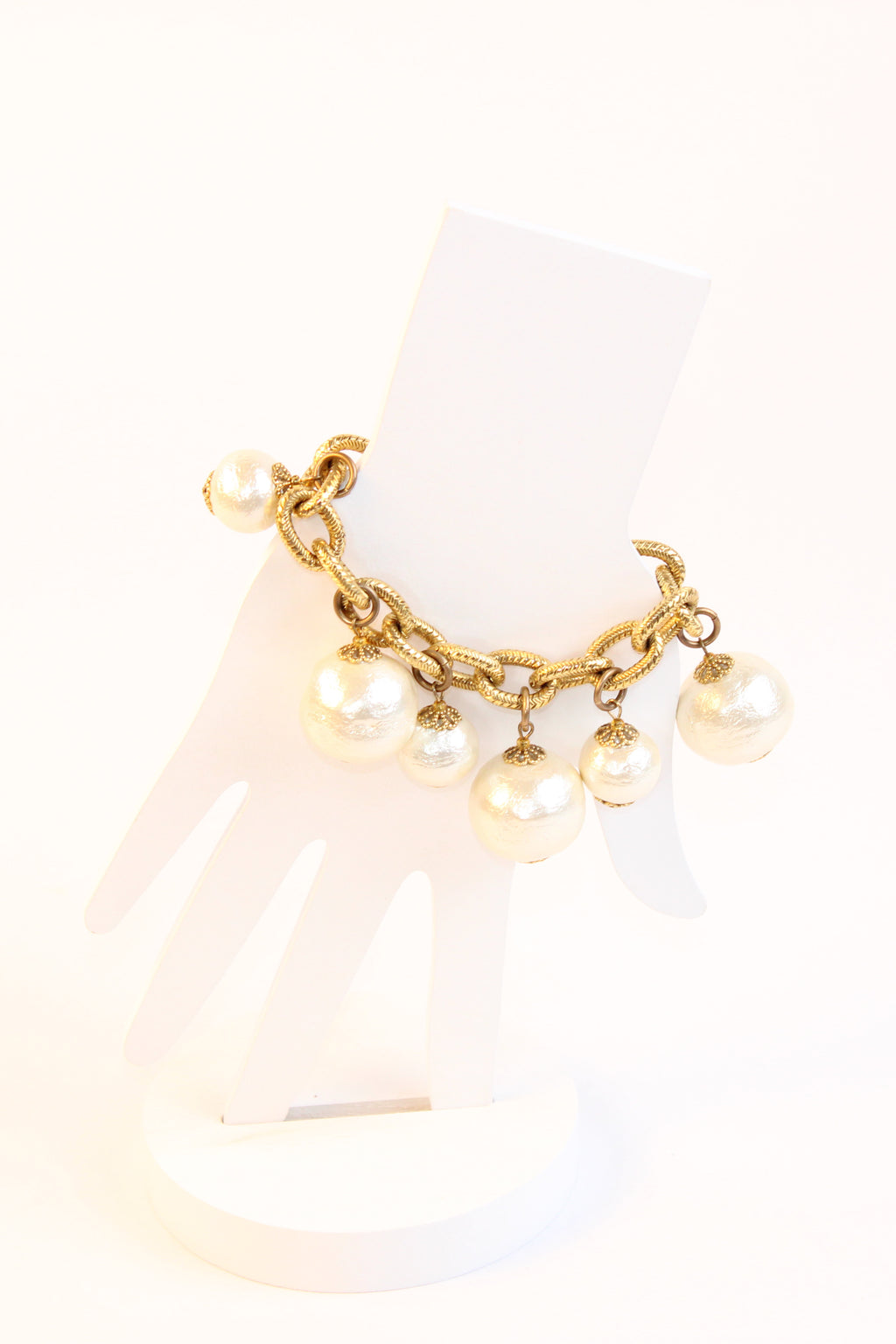 Textured gold tone bracelet with pearl drop charms