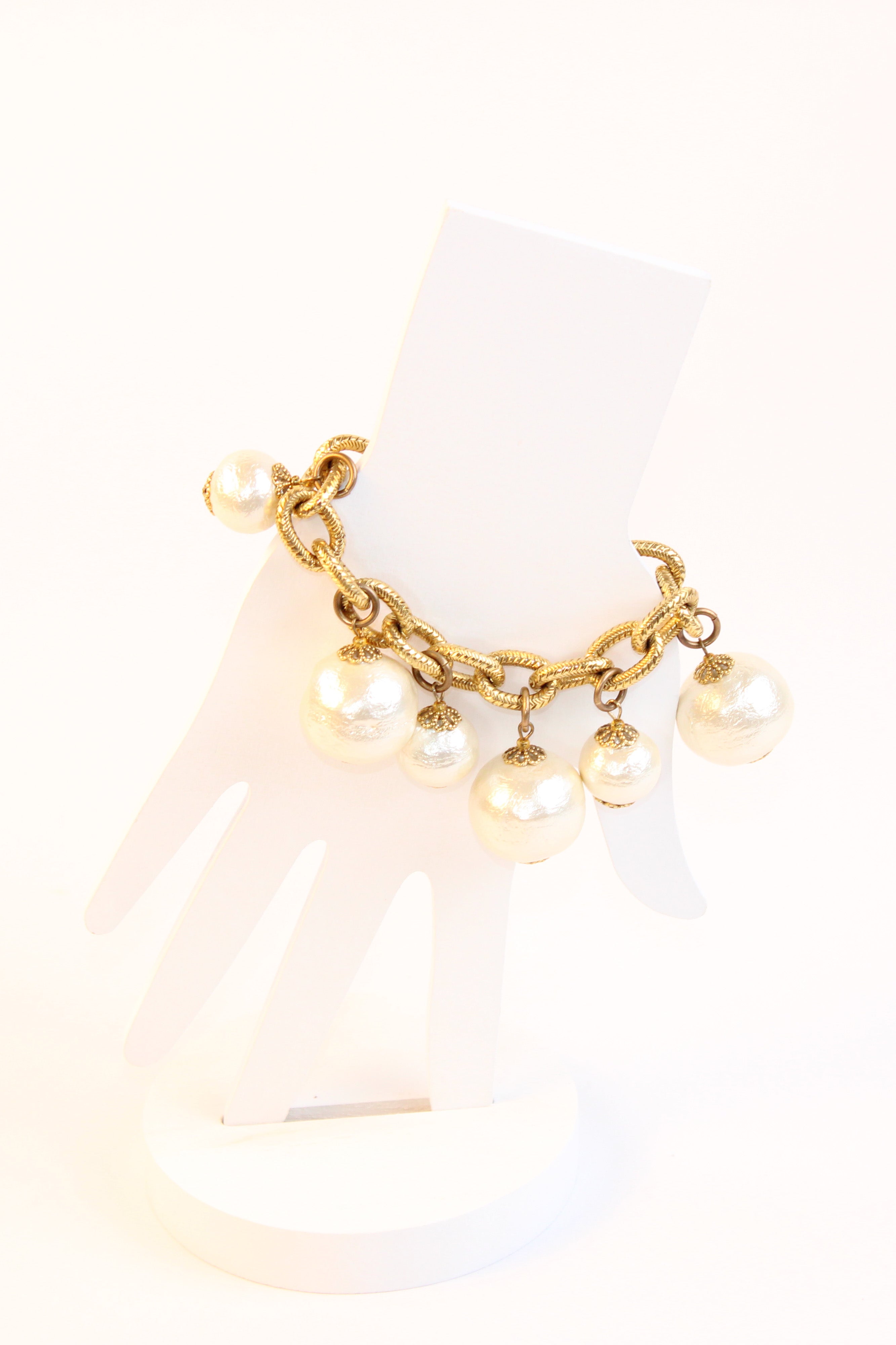 Textured gold tone bracelet with pearl drop charms