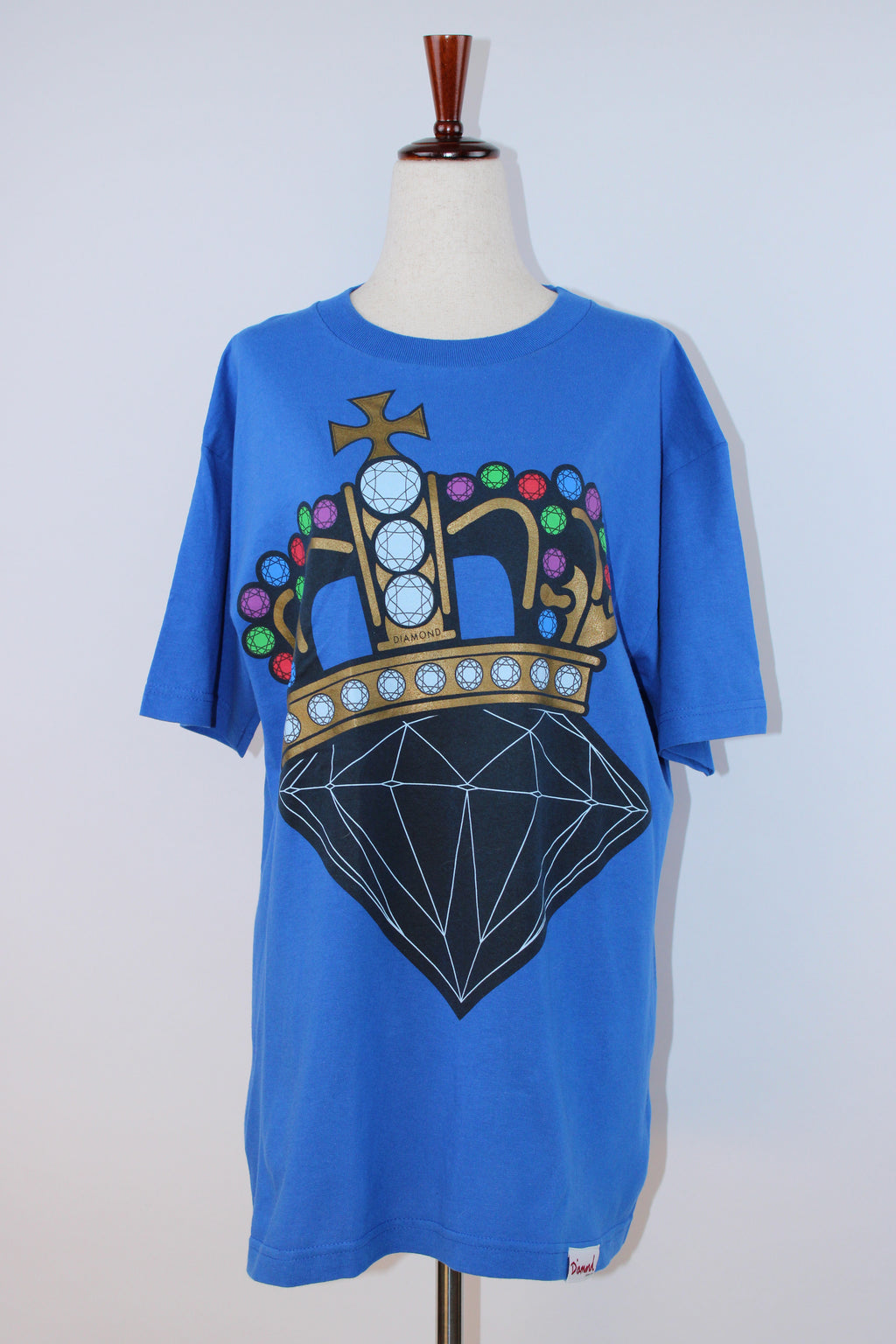 Diamond Supply Co. blue cotton T-shirt featuring a large multicolor crown and diamond graphic on the front displayed on a mannequin.