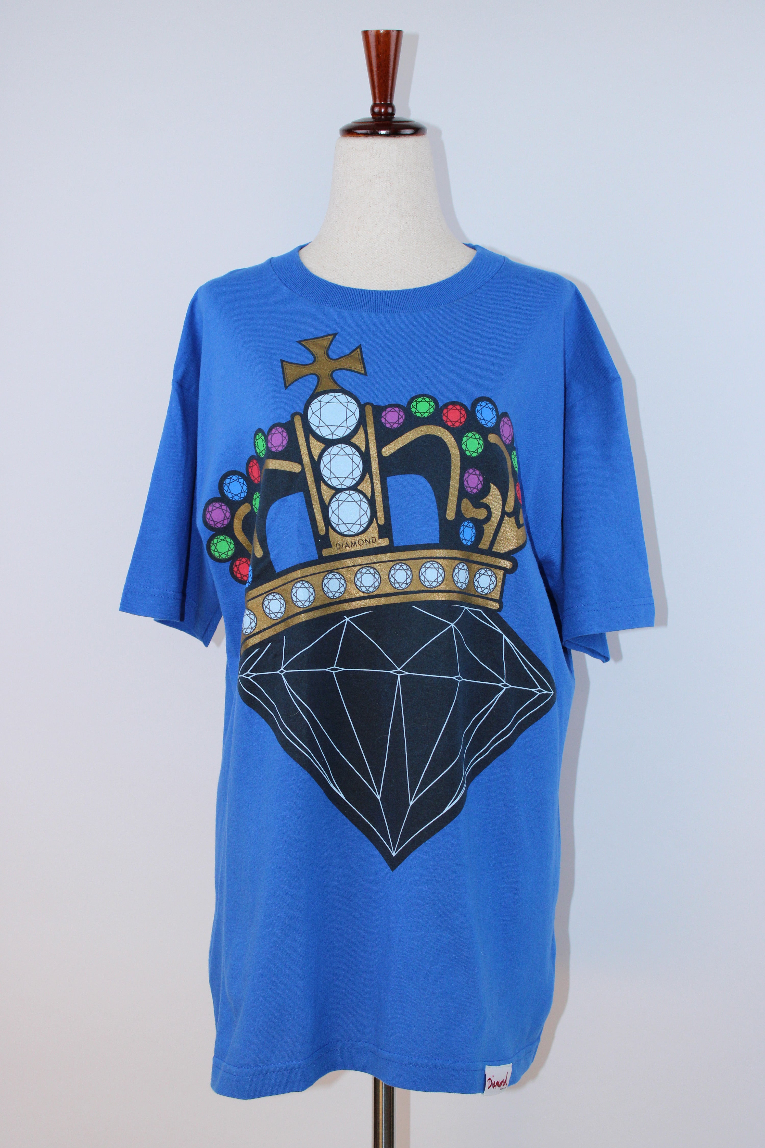 Diamond Supply Co. blue cotton T-shirt featuring a large multicolor crown and diamond graphic on the front displayed on a mannequin.
