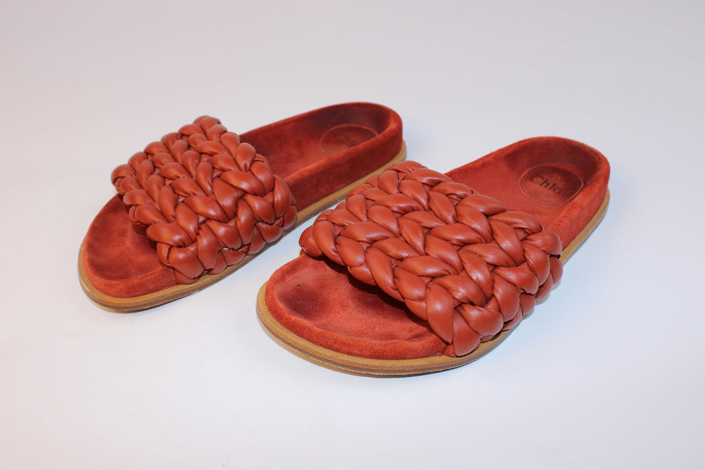 Chloé braided terracotta leather flat slide sandals with oversized woven leather straps and suede footbeds.