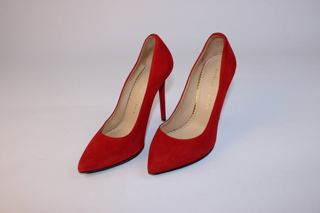 Charlotte Olympia red suede pointed-toe stiletto pumps with signature heart-shaped leather soles displayed on a white background.